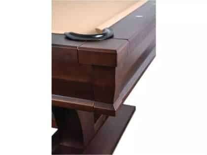 Corner of a dark brown wooden piano showing joined panels and a curved black handle on top, highlighting woodwork.