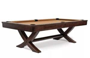 Dark wood pool table with beige felt, six pockets, and curved cross-legged supports.