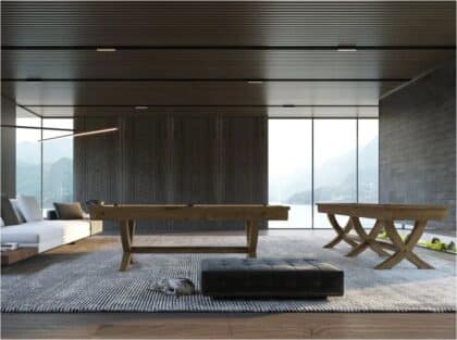 Modern living room with a wooden pool/billiards table, sofa, and benches; large windows reveal a mountain landscape, a cat sits near a black ottoman.