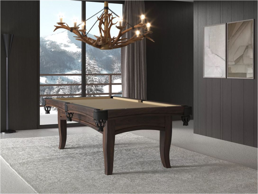 Luxurious dark wood billiards table in a modern room with an antler chandelier and a snowy mountain view outside the window.