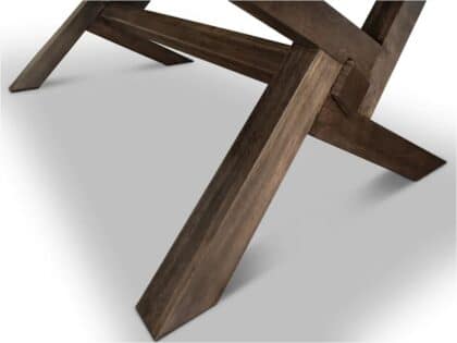 Close-up of dark brown wooden table legs intersecting in an X-like cross on a light surface.
