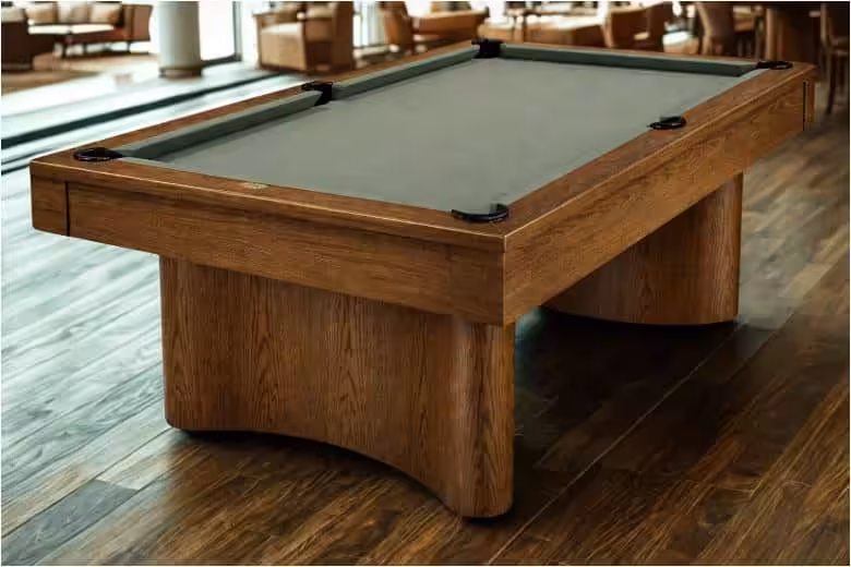 Oceanside20charcoal202026 | Oceanside | West Penn Billiards Wooden pool table with green felt in a lounge on a dark hardwood floor, with seating in the background.